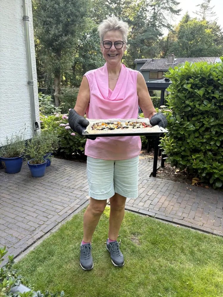Jenny Oldenhuis in de tuin met een zelfgemaakte pizza